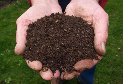 person holding dark, crumbly soil
